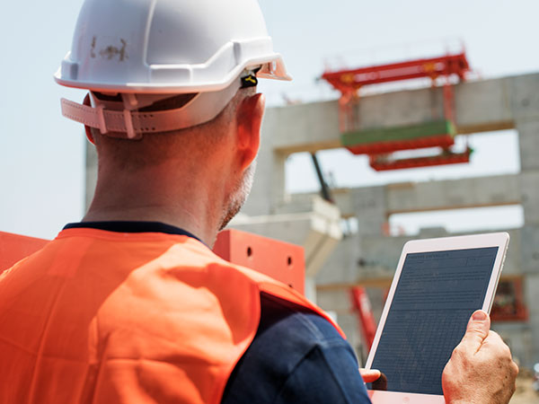 Technicien Be-Di tenant une tablette avec un diagnostic énergique complet d'une maison, énergie